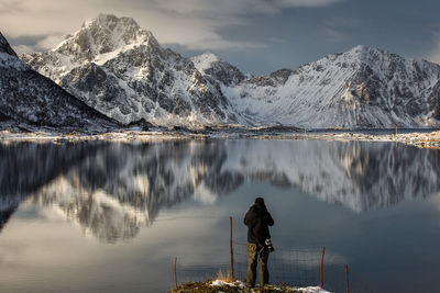 Rear view of man on snowcapped mountains against sky