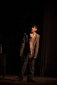 Teenage boy looking away while standing on stage