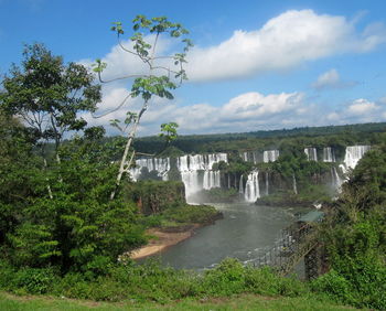 Scenic view of waterfall against sky