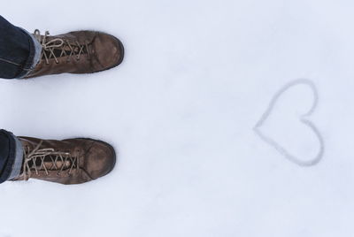 Low section of person standing on snow