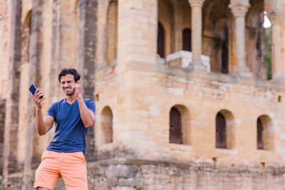 Low angle view of man standing against historic building