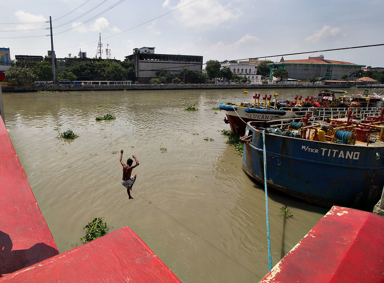 PEOPLE IN BOAT AGAINST CANAL