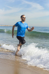 Man running on shore at beach