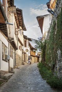 People walking on footpath amidst buildings in city