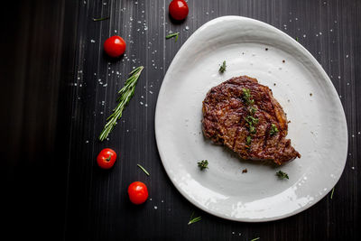 Steak on a plate with tomatoes and rosemary