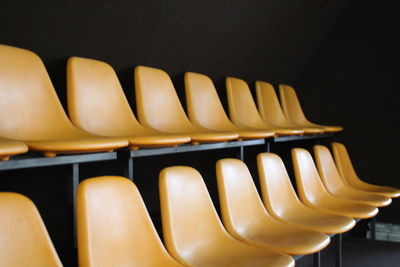 Close-up of empty chairs against black background