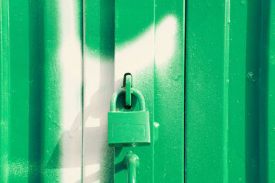 Green padlock on green and white door