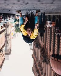 Portrait of man with arms outstretched against built structure