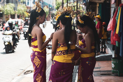 Rear view of people standing on street