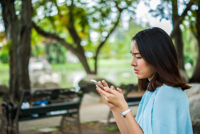 Young woman using smart phone outdoors