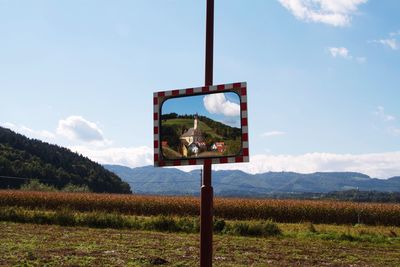 Basketball hoop on field against sky