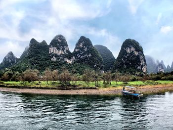 Scenic view of river and mountains against sky