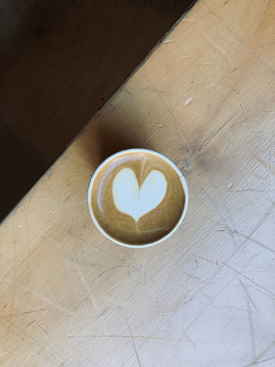 HIGH ANGLE VIEW OF COFFEE CUP ON TABLE WITH TEXT