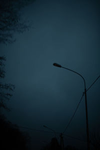 Low angle view of silhouette street light against sky at dusk