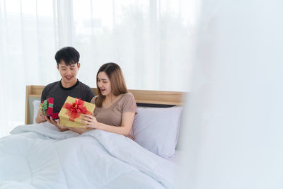 Young couple sitting on bed