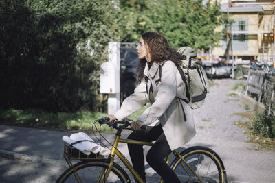 Side view of woman riding bicycle on street