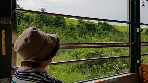 Rear view of man against window