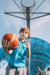 Low angle view of boy ball in amusement park against sky