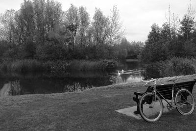 Bicycle by lake against sky
