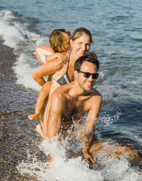 Happy friends enjoying in water at shore