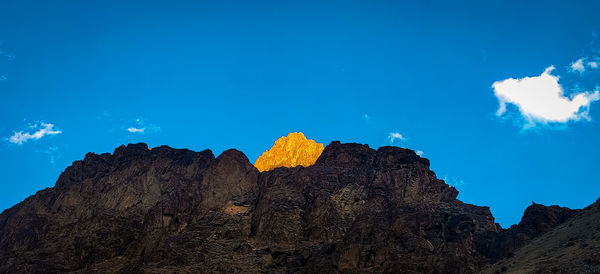 Low angle view of rocks against blue sky