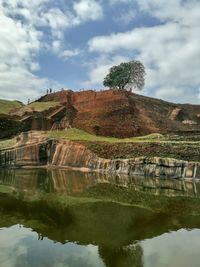 Reflection of tree on lake against sky