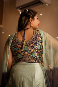 Young woman looking away while sitting at home