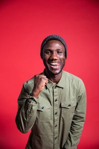 Portrait of a smiling mid adult man against red background