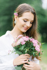 Portrait of young woman holding bouquet