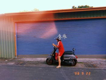 Man riding motor scooter on street