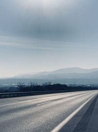 Road amidst field against sky