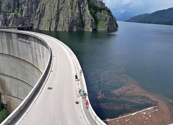 High angle view of sea by mountain against sky