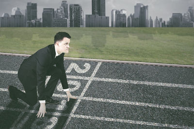 Full length of businessman at starting line on sports track