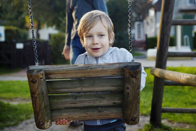 Portrait of smiling boy on slide at playground