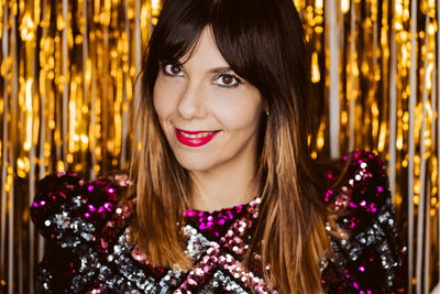 Portrait of smiling young woman standing against decorations