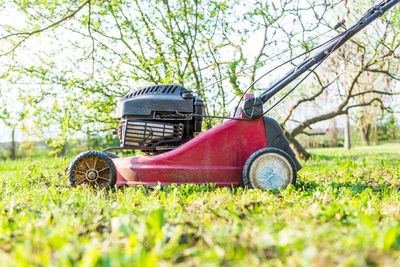 Close-up of lawn mower on field