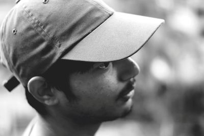 Side view of thoughtful man wearing cap