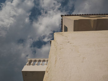 Low angle view of building against cloudy sky