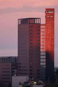 Buildings in city against sky during sunset