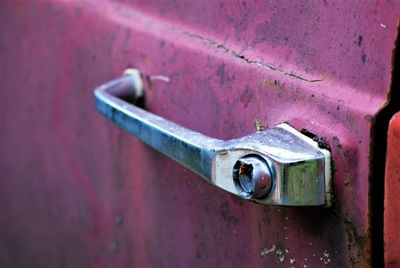 Close-up of rusty metallic handle on car door 