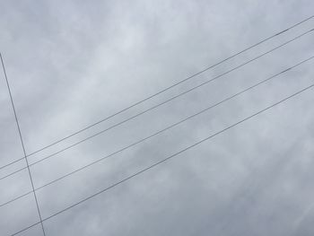 Low angle view of power lines against sky