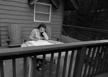 Woman sitting on table by railing