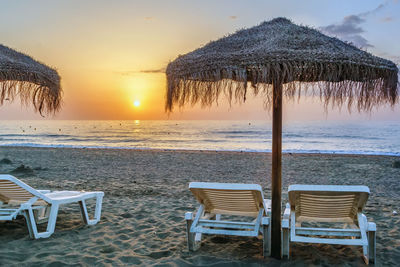 Sunbed and umbrella on the sunset background, torremolinos, spain