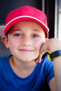 Portrait of smiling boy wearing cap sitting at home