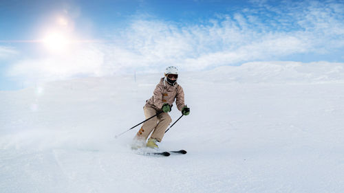 Person with umbrella on snow against sky