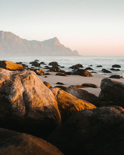 Scenic view of beach against clear sky during sunset