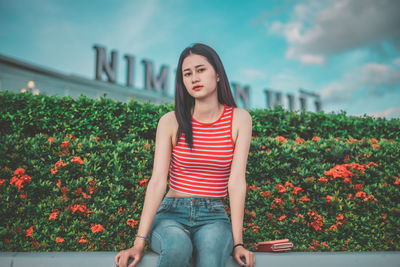 Portrait of a beautiful young woman sitting outdoors