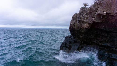 Rock formation in sea against sky