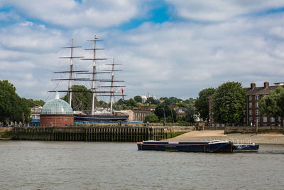 Sailboats in river against buildings in city