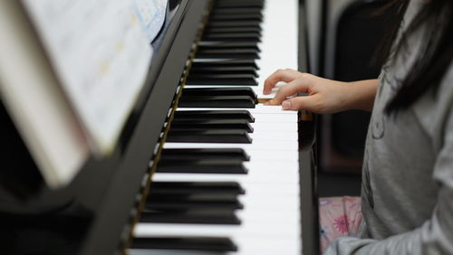 Midsection of kid playing piano